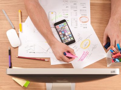 Website wireframes sketched beside a phone